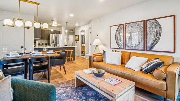 Un salon moderne avec un canapé, une table basse et un coin repas.