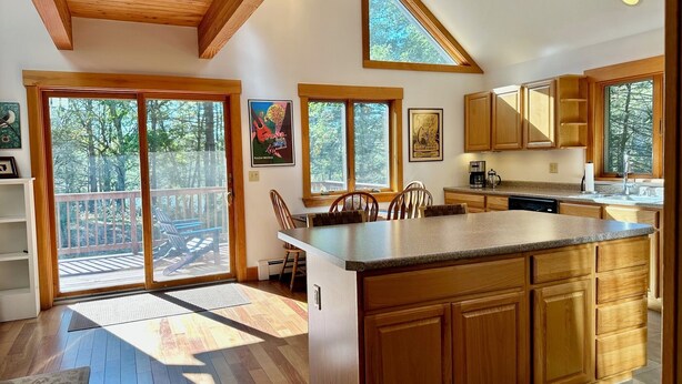 A spacious kitchen with wooden cabinets, a large island, and a view of the outdoors.