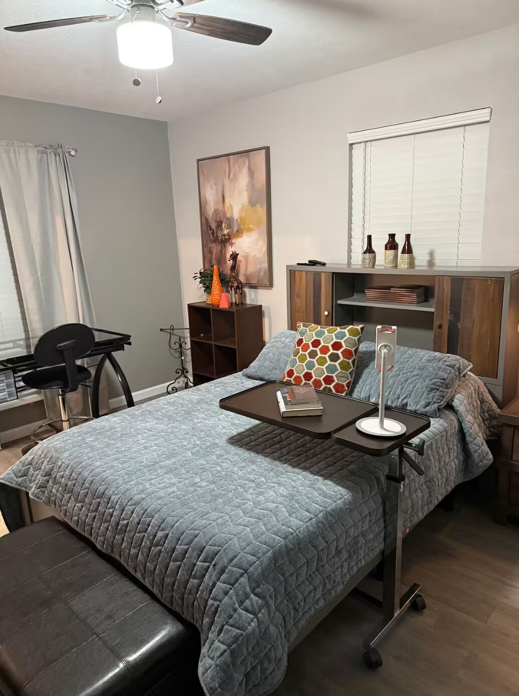 Une chambre moderne avec un lit, une table de chevet et un bureau avec une chaise.