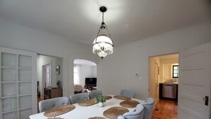 A dining area with a white table, blue upholstered chairs, and woven placemats. - Snowhawk House in Historic Wallace located close to many outdoor adventures! (Wallace)