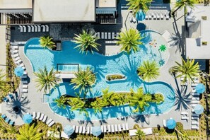 An aerial view of a resort with a central swimming pool surrounded by palm trees and sun loungers. - ParadisoGrande 5BD/5BH "2mi SeaWorld" FREE Resort (Orlando)
