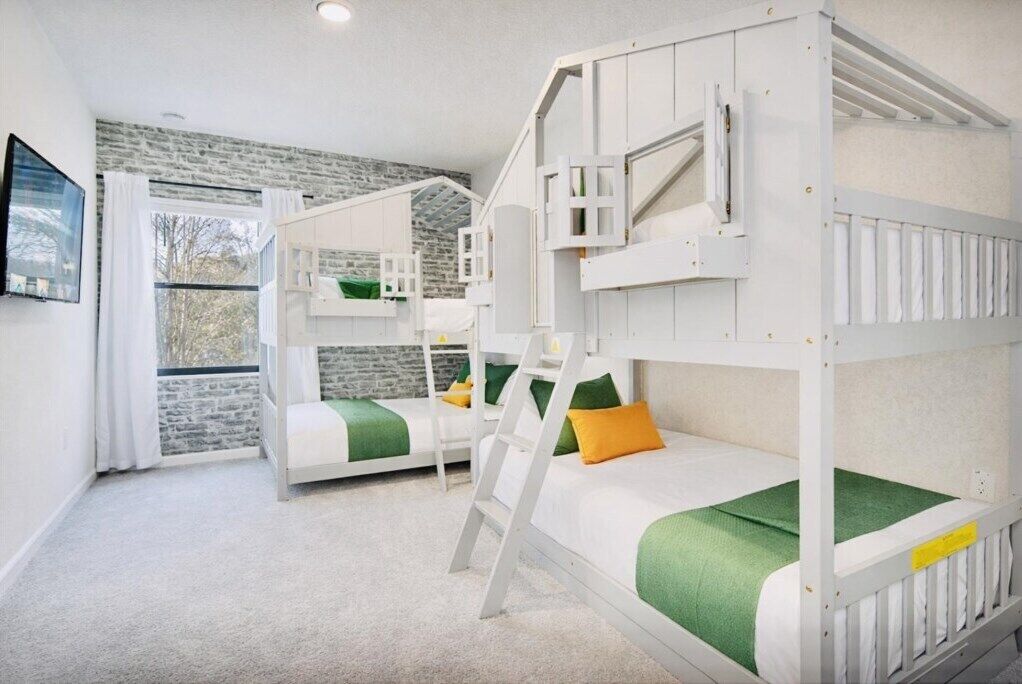 Een kinderkamer met stapelbedden, een ladder en een stenen muur.