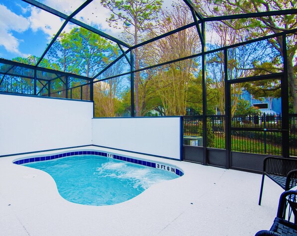 A swimming pool with a 6ft depth and 3ft 6in width, surrounded by a glass enclosure with a view of trees and a clear sky. - ParadisoGrande 5BD/5BH "2mi SeaWorld" FREE Resort (Orlando)