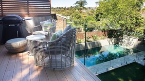 A patio with wicker furniture, a grill, and a swimming pool. - Casa Piscina, Coogee Isyd (Coogee)