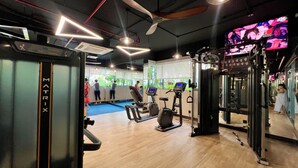A gym with exercise equipment, a mirrored wall, and a ceiling fan. - CELEDON Tân Phú (Ho Chi Minh City)