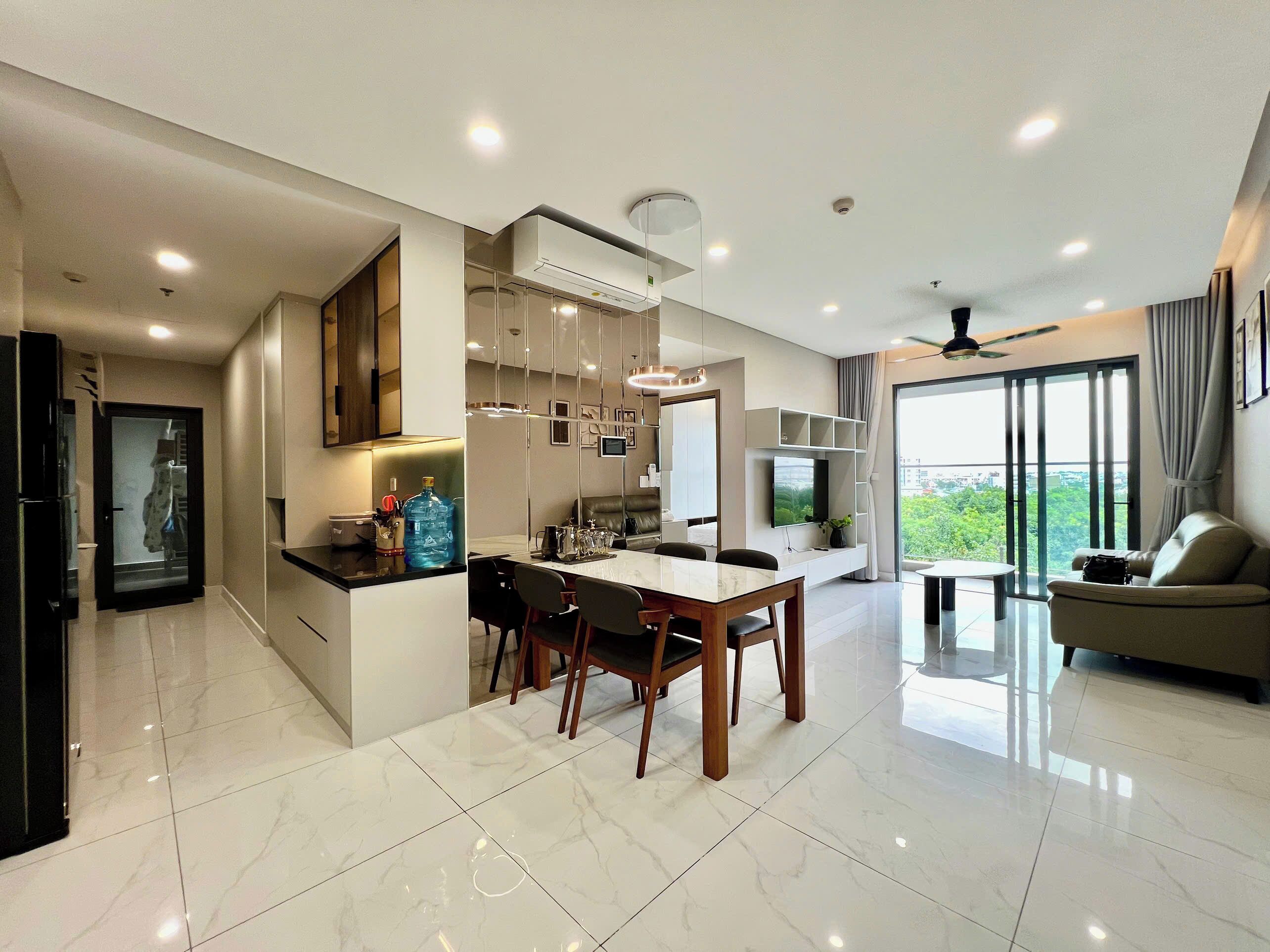 A modern living space with a dining area, kitchen, and seating area.