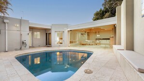 A modern house with a swimming pool, a patio, and a kitchen area. - Trigg Coastal House - Beachfront Bliss with Sunset Views (Trigg)