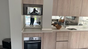 A modern kitchen with wooden cabinets, a built-in oven, a sink, and a countertop. - Nuñoa... one step away from everything you need (apartment 1105) (Ñuñoa)