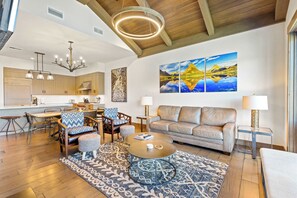 A modern living room with a sofa, armchairs, a coffee table, and a rug.