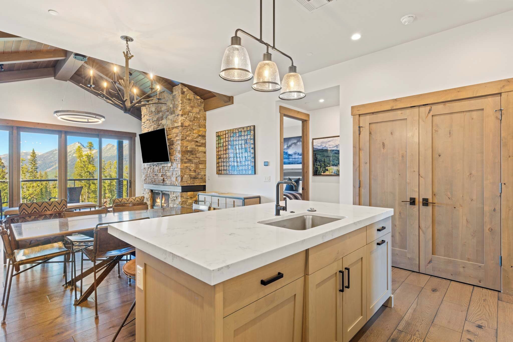 Una cocina amplia con una isla grande, armarios de madera y una pared decorativa de piedra.