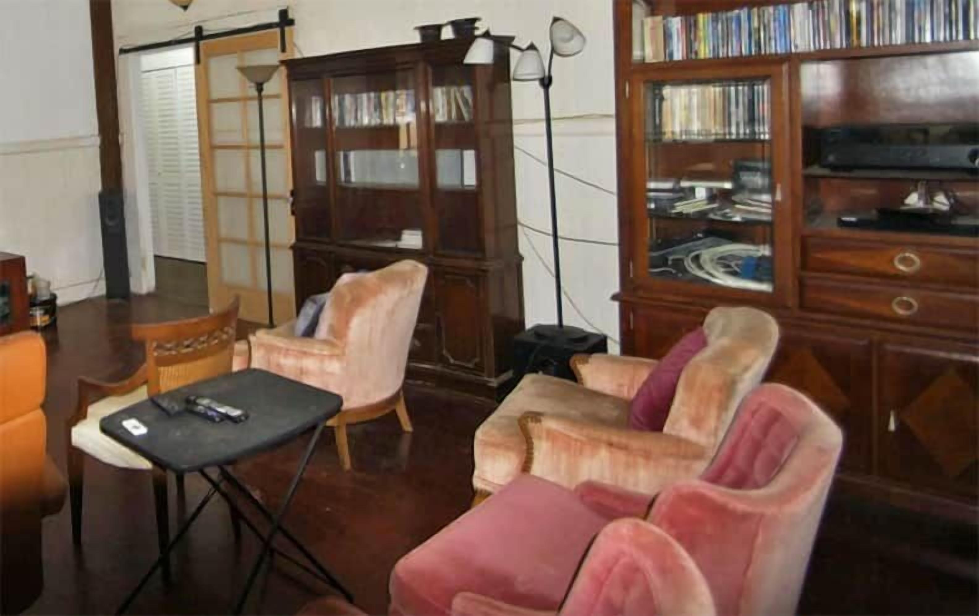 A room with a wooden cabinet, a table, and two chairs.