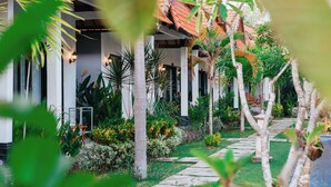 Un resort tropical con un camino que lleva a un edificio de techo con tejas.