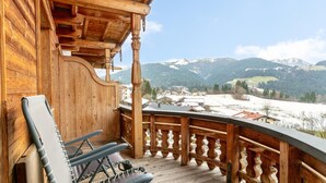 A wooden balcony with a view of a snowy mountain landscape.