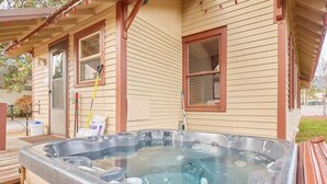 Ein Whirlpool vor einem Haus mit Holzverkleidung und einer Veranda.