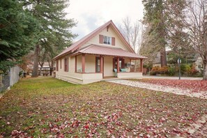 Ein eingeschossiges Haus mit Satteldach, einer Veranda und einem kleinen Vorgarten mit herabgefallenen Blättern.