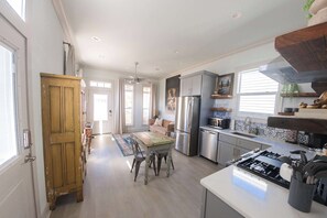 A spacious kitchen with a central island, stainless steel appliances, and a dining area with a wooden table and chairs.