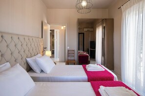 Une chambre d’hôtel avec deux lits, une grande tête de lit, un miroir et une vue sur le couloir.
