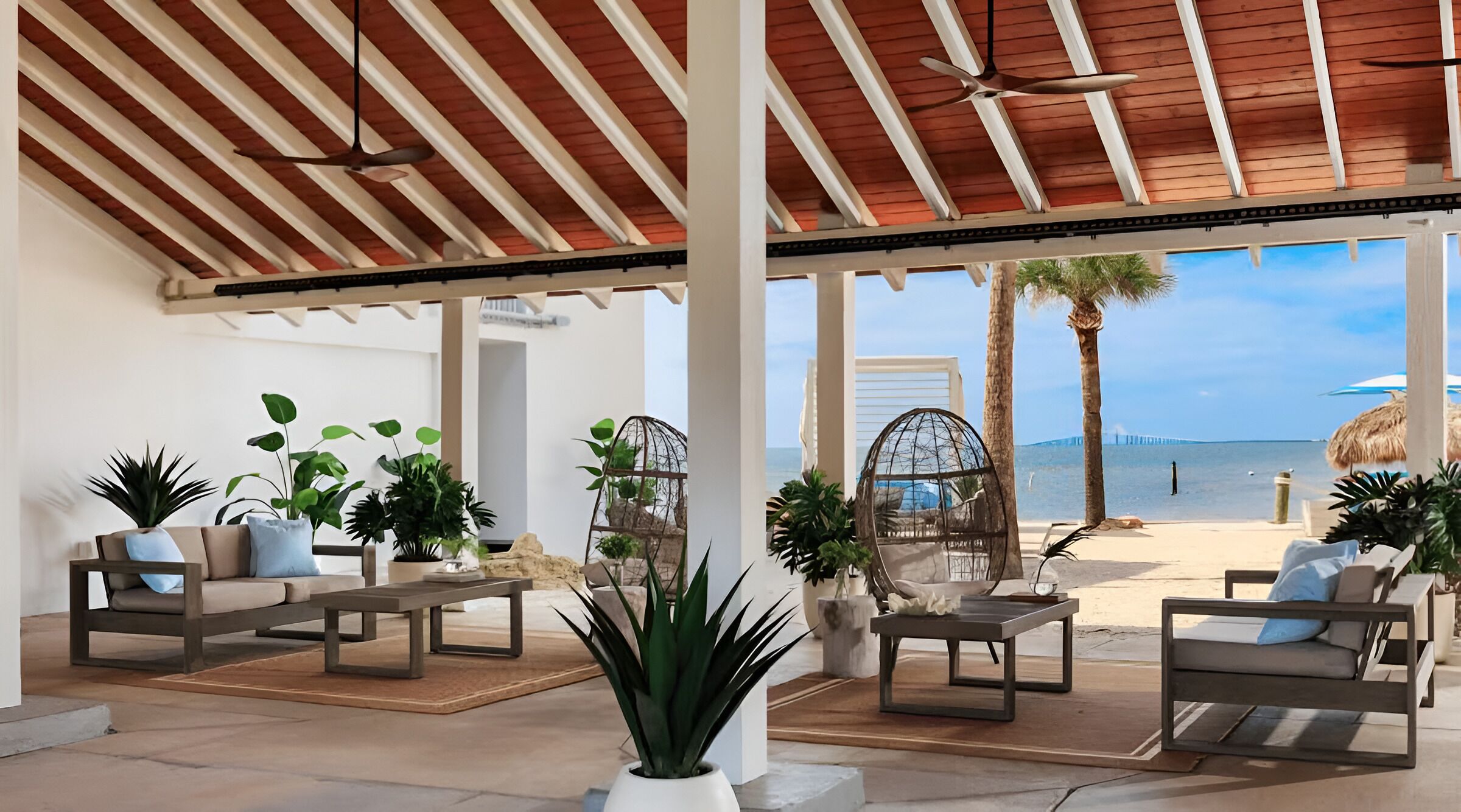 Unwind under shaded seating with sweeping beachfront views.