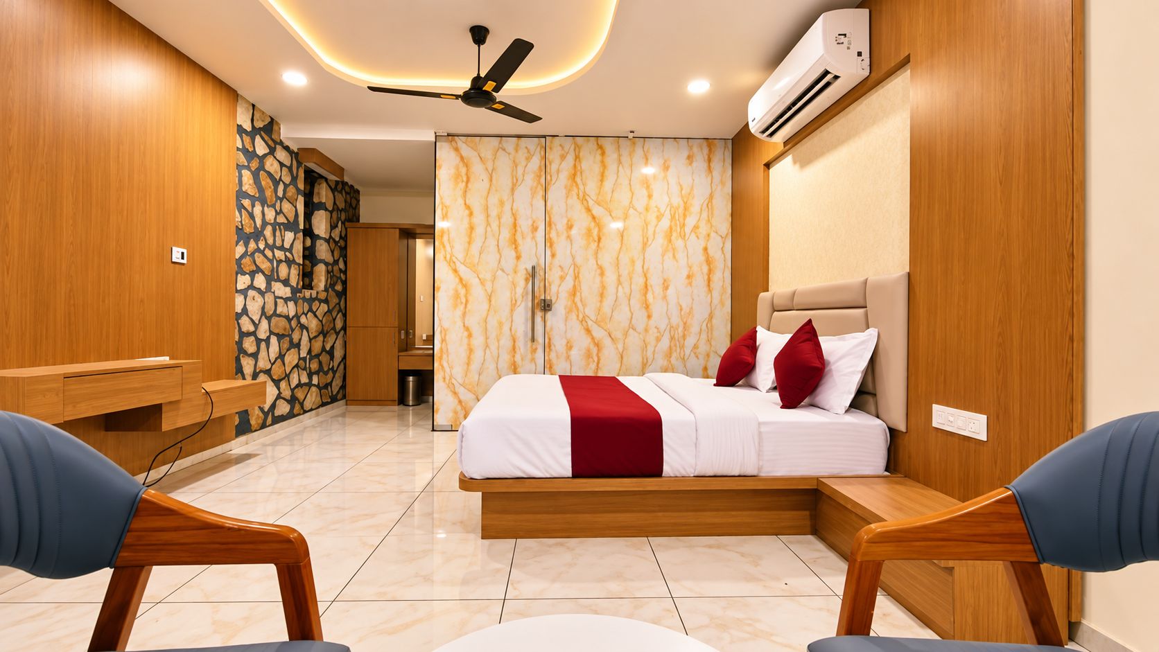 A modern bedroom with a bed, bedside tables, a ceiling fan, and an air conditioning unit.
