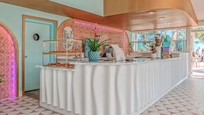 A reception area with a white counter, a menu board, and a potted plant. - 2 Units | Luxurious Room Steps to Downtown Attractions & Tranquility (St. Petersburg)