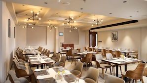 A conference room with multiple tables and chairs, equipped with nameplates and water glasses. - GOLDEN CASTLE (Neyyattinkara)