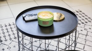 A round table with a candle, a remote control, and a tray. - Studio 30s from RER E - Paris in 20 min! (Villemomble)