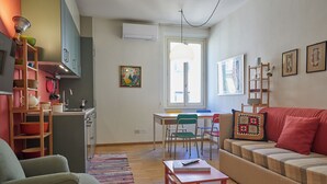 A compact living space with a kitchenette, a dining area, and a seating area with a sofa and chairs. - Charming and quiet two-room flat in Porta Romana (Milano)