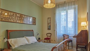 A bedroom with a bed, a desk, a chair, and a lamp. - Charming and quiet two-room flat in Porta Romana (Milano)