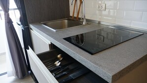 A kitchen with a double sink, a built-in stove, and a drawer with utensils. - Blue Edge Studio T3-527 (Chalong)