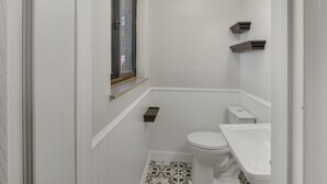 A small, white bathroom with a toilet, sink, and window. - 3-bedroom pet friendly house with AC in Shady Spring- close to Winterplace! (Shady Spring)