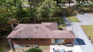 A two-story brick house with a covered patio, a garage, and a driveway. - 3-bedroom pet friendly house with AC in Shady Spring- close to Winterplace! (Shady Spring)