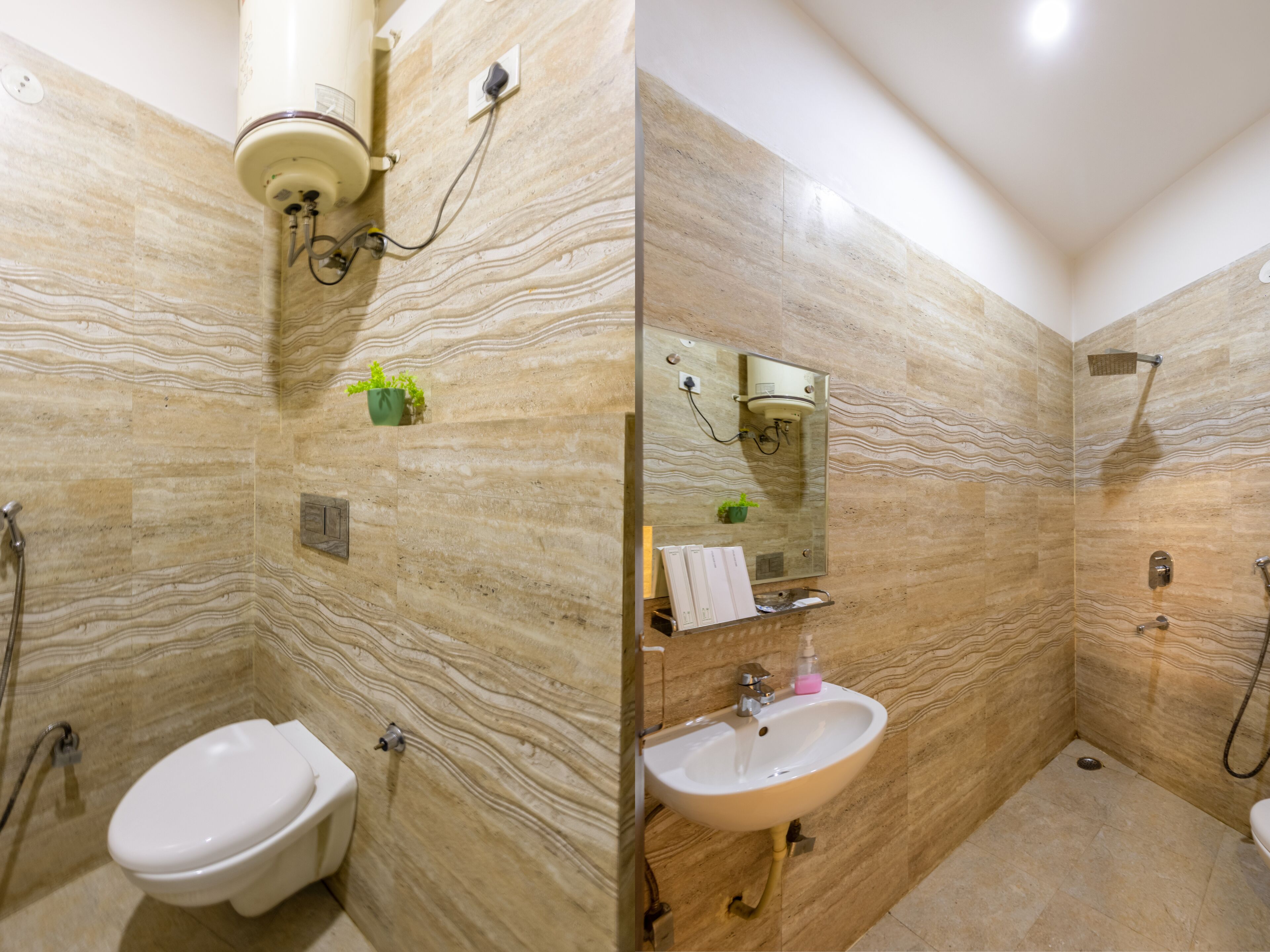 A bathroom with a marble wall, a toilet, a sink, and a shower.