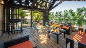 An outdoor deck with wicker furniture, a grill, and potted plants. - AR PAVILHON Villa ****, à 50 m de la plage pour un séjour unique à Douarnenez (Douarnenez)