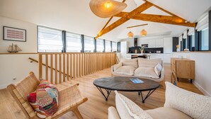A spacious living area with a high ceiling, wooden beams, and large windows. - AR PAVILHON Villa ****, à 50 m de la plage pour un séjour unique à Douarnenez (Douarnenez)