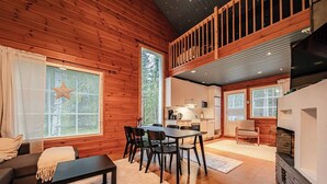 Ein gemütliches Blockhaushaus-Interieur mit Essbereich, Küche und Sitzgelegenheit.