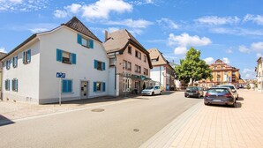 A street with buildings, cars, and a clear sky.