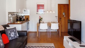 A compact living space with a kitchen, dining area, and a seating area with a television.