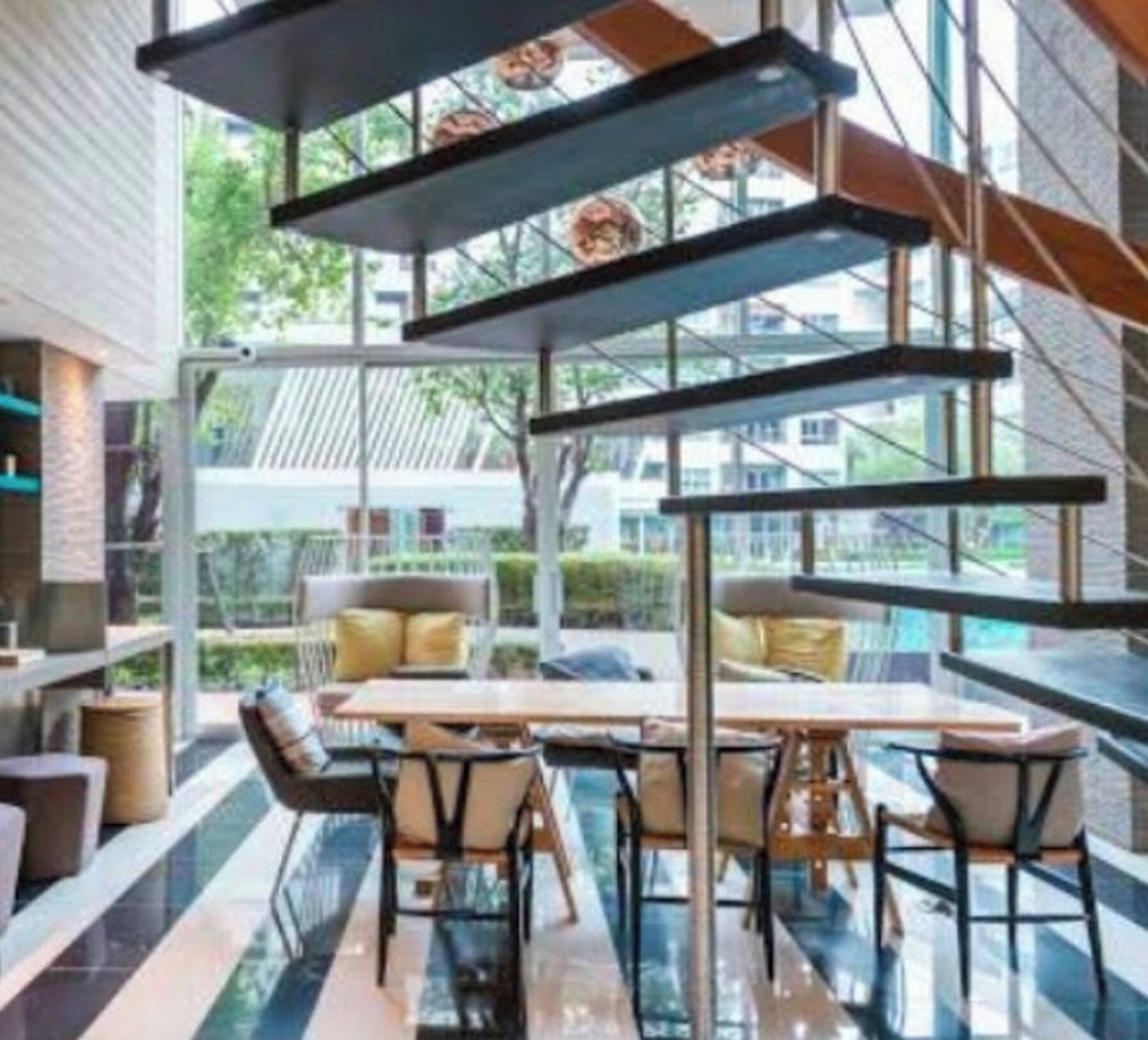 A modern interior with a glass wall, a dining area with a table and chairs, and shelves with decorative items.