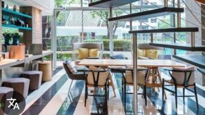 A modern interior with a dining area, shelves with bottles, and a view through large windows. - Elio Del Ray Studio walk to BTS Bill included​ (Bangkok)