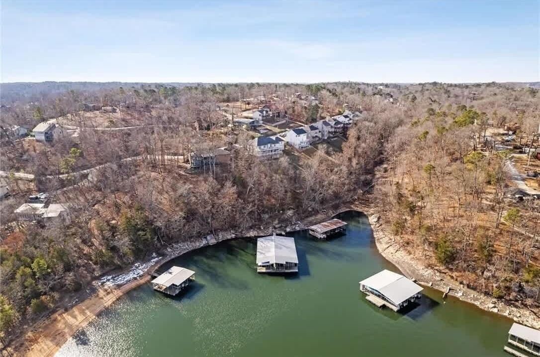 An aerial view of a lakeside residential area with houses and docked boats.