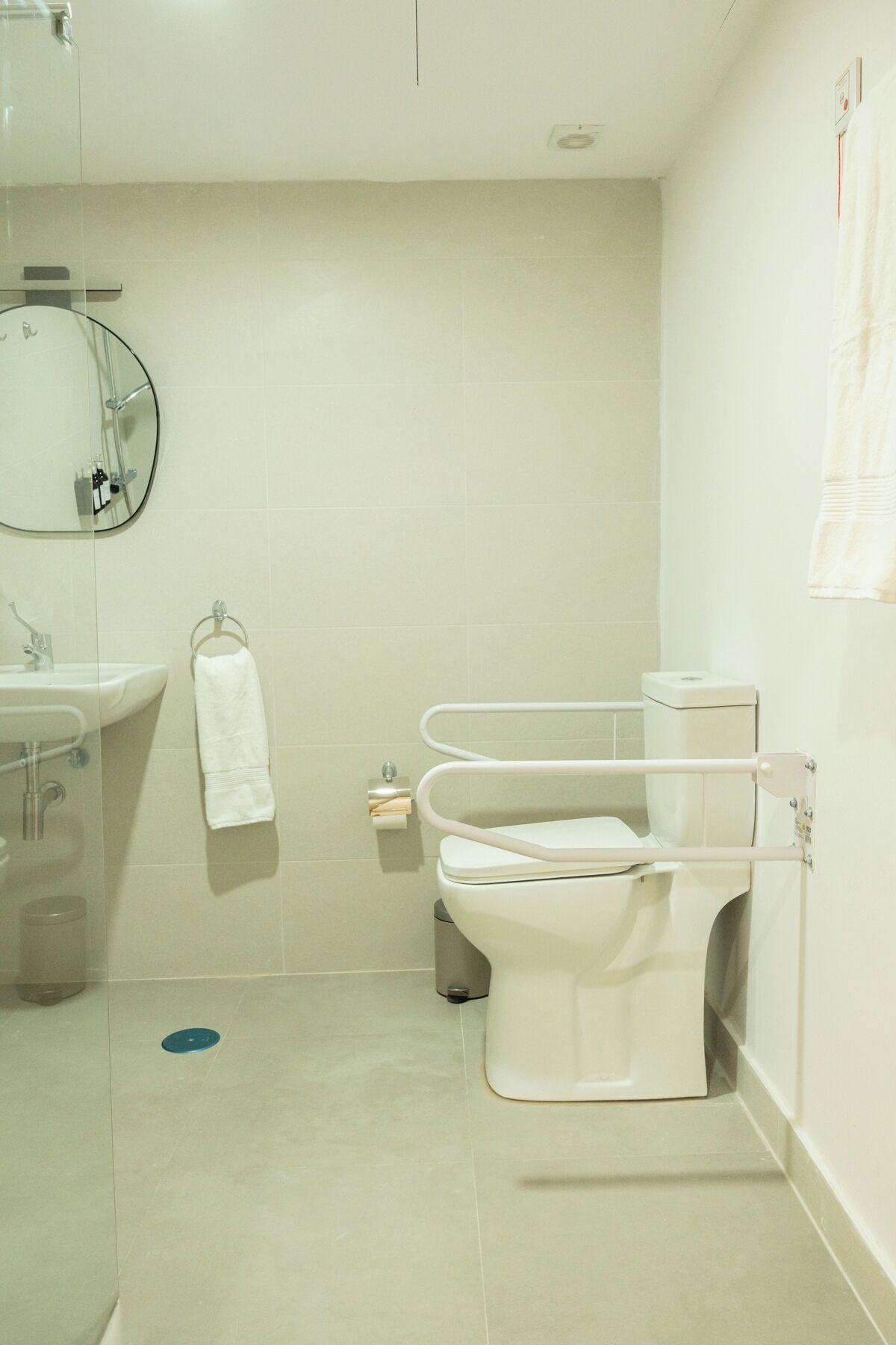 A modern bathroom with a toilet, sink, and glass shower enclosure.