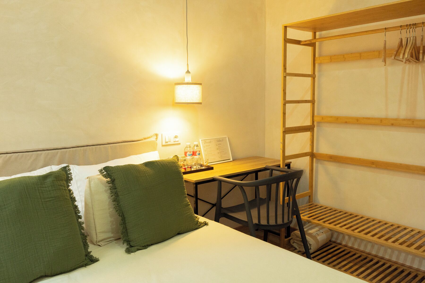 Habitación con literas, escritorio, silla y una pequeña estantería.