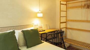 Habitación con literas, escritorio, silla y una pequeña estantería.