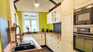 Una cocina con pileta, estufa, horno y alacenas.