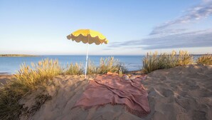 Uma praia com uma toalha e um guarda-sol.