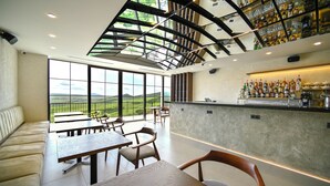 Un ristorante moderno con soffitti alti, ampie finestre e un'area bar.