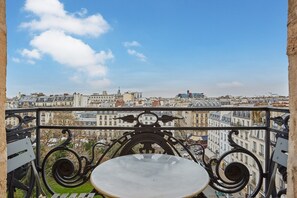 Un balcone con vista su un panorama urbano, con edifici e cielo sereno.