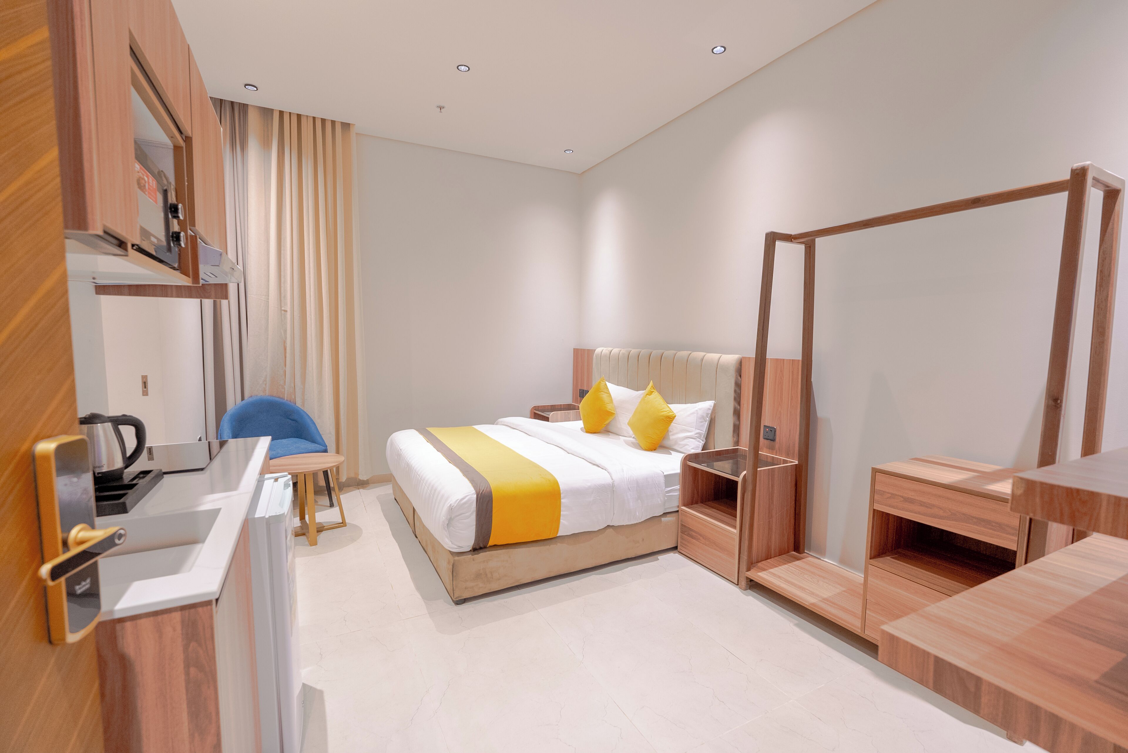 Una habitación de hotel moderna con una cama, mesitas de noche, un escritorio y una silla.