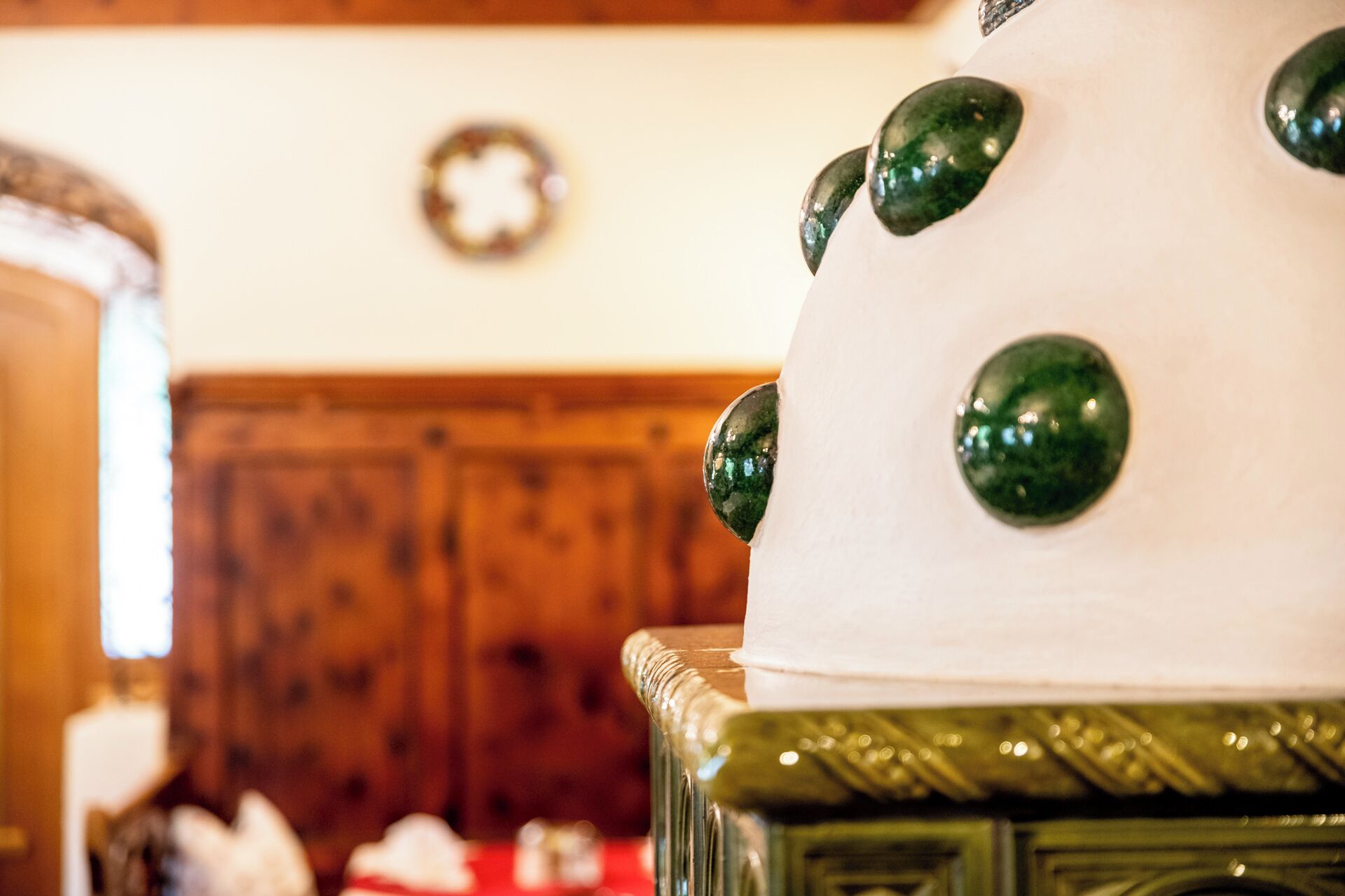 A close-up of a white cake with green decorative elements on a glass stand.