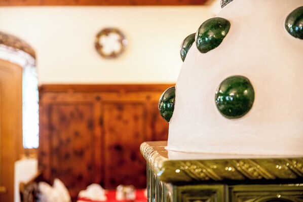 A close-up of a white cake with green decorative elements on a glass stand. - Hotel Heitzmann (Mittersill)